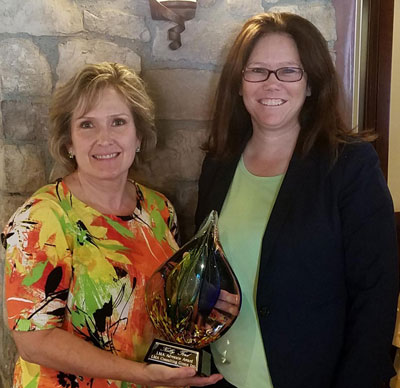 Image of Lisa Anderson presenting the 2018 LMA Advocate Award to Kelly Ford
