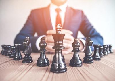 Business leader evaluating agile strategy on a dynamic marketplace chessboard