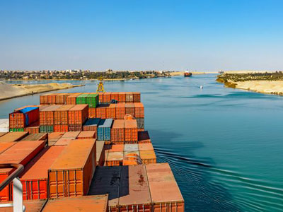 Suez Canal ship blockage causing global supply chain disruption, with containers piled up in the canal